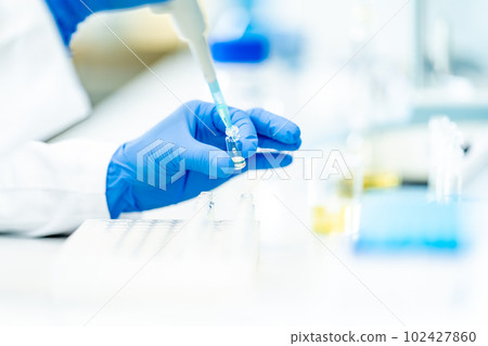 pipetting of chemical samples during research in a biochemical scientific laboratory 102427860