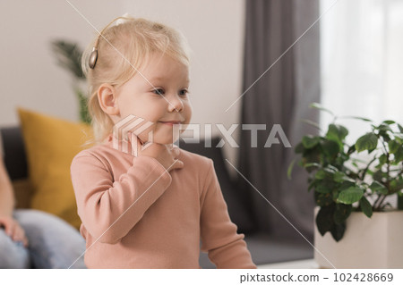 Funny baby with cochlear implant. Hear aid and medicine innovating technology and diversity concept 102428669
