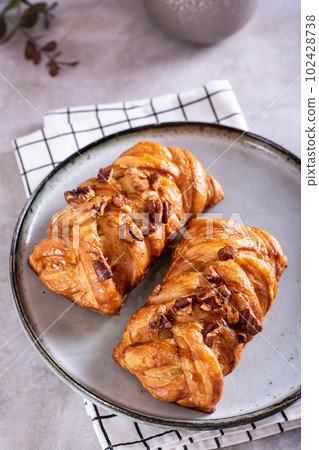 Swedish fika time with close up of  cinnamon buns nuts and maple syrup  on the table vertical view 102428738