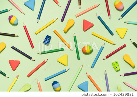 Colored Pencils and rubber erasers background pattern on light green. Back to School or drawing and creativity concept. Copy space in center. Top view Colored Pencils and rubber erasers background pattern on light green. Back to School or drawing and creativity concept. Copy space in center. Top view 102429881