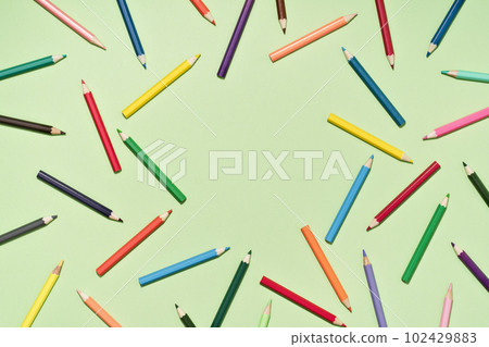 Colored Pencils background pattern on light green. Back to School or drawing and creativity concept. Copy space in center. Top view Colored Pencils background pattern on light green. Back to School or drawing and creativity concept. Copy space in center. Top view 102429883