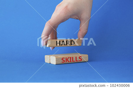 Hard skills symbol. Wooden blocks with words Hard skills. Beautiful blue background. Businessman hand. Business and Hard skills concept. Copy space. 102430006