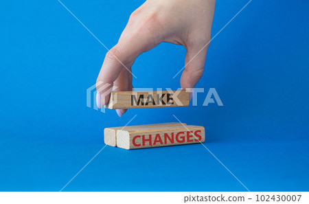 Make changes symbol. Wooden blocks with words Make changes. Beautiful blue background. Businessman hand. Business and Make changes concept. Copy space. 102430007