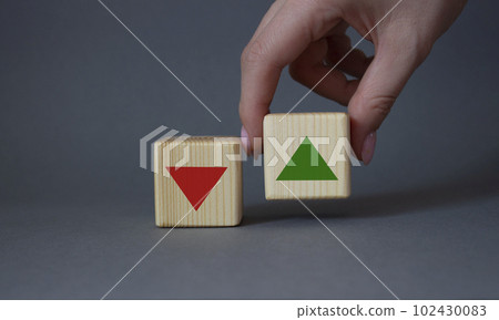 Interest rate symbol. Businessman hand is making a choice between two cubes with arrow going down and arrow going up. Beautiful grey background. Business interest rate concept. Copy space. Interest rate symbol. Businessman hand is making a choice between two cubes with arrow going down and arrow going up. Beautiful grey background. Business interest rate concept. Copy space. 102430083