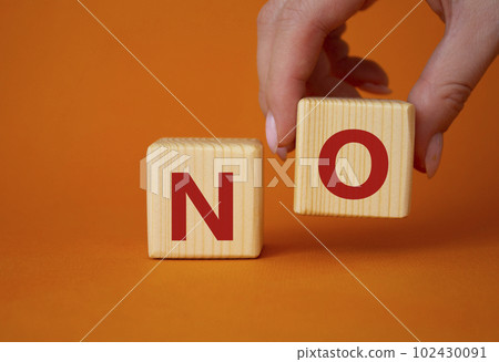 No symbol. Concept words No on wooden blocks. Businessman hand. Beautiful orange background. Business and No concept. Copy space. No symbol. Concept words No on wooden blocks. Businessman hand. Beautiful orange background. Business and No concept. Copy space. 102430091