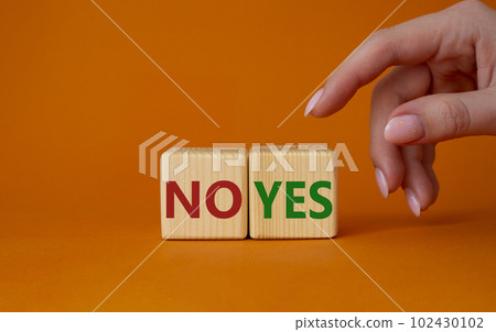 Yes vs No symbol. Businessman hand is making a choice between YES and No symbol. Beautiful orange background. Business concept. Copy space. Yes vs No symbol. Businessman hand is making a choice between YES and No symbol. Beautiful orange background. Business concept. Copy space. 102430102