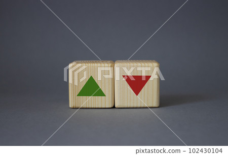 Interest rate symbol. Two wooden cubes with arrow going down and arrow going up. Beautiful grey background. Business interest rate concept. Copy space. Interest rate symbol. Two wooden cubes with arrow going down and arrow going up. Beautiful grey background. Business interest rate concept. Copy space. 102430104