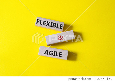 Flexible and agile symbol. Concept word Flexible and agile on wooden blocks. Beautiful yellow background. Business and Flexible and agile concept. Copy space 102430139