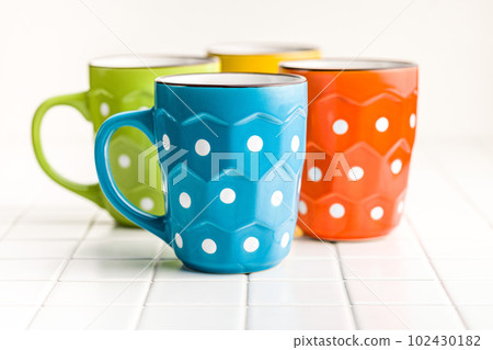 The polka dot mugs on kitchen table. 102430182