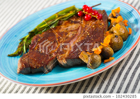 Fried beef loin with grilled asparagus and mushrooms 102430285