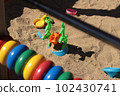 Plastic toys in the sandbox at the playground. Car, saucer, butterfly 102430741