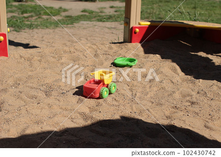 Plastic toys in the sandbox at the playground. Car, saucer Plastic toys in the sandbox at the playground. Car, saucer 102430742
