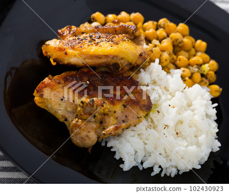 Tasty chicken thighs with cheakpea and rice at plate Tasty chicken thighs with cheakpea and rice at plate 102430923