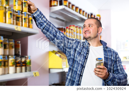 Man purchasing peanut butter in grocery Man purchasing peanut butter in grocery 102430924