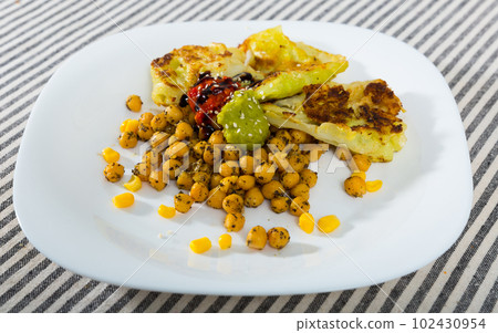 Photography of plate with cabbage leaves in batter with garbanzos and sauce 102430954