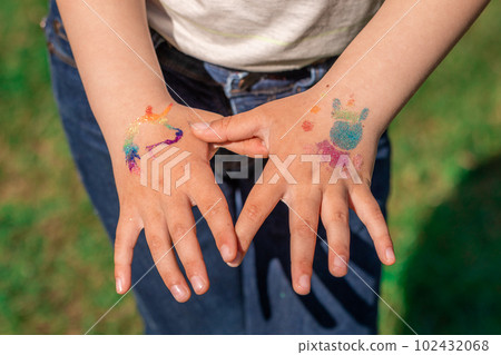 Shimmering sparkling glitter tattoo on a child's hand at a birthday party 102432068