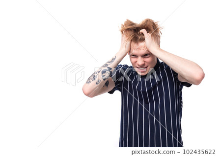 worried unhappy 25s blond man dressed in a tank top with tattoos clutching his head worried unhappy 25s blond man dressed in a tank top with tattoos clutching his head 102435622