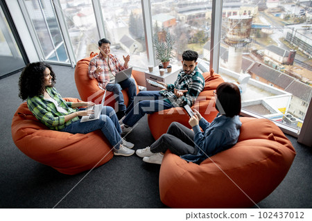 Entrepreneurs utilizing devices while talking in workplace Entrepreneurs utilizing devices while talking in workplace 102437012