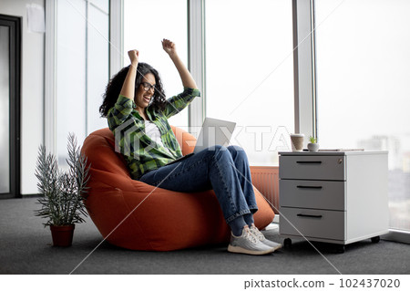 Freelancer raising arms in joy after deal online via laptop Freelancer raising arms in joy after deal online via laptop 102437020