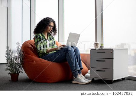 Female using computer during coffee break at work 102437022