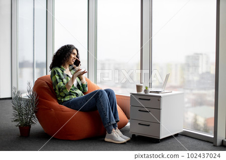 Lady having conversation on phone with coworkers indoors Lady having conversation on phone with coworkers indoors 102437024