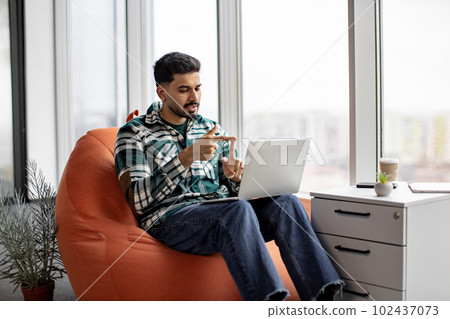 Handsome indian man gesturing hands while speaking on video 102437073