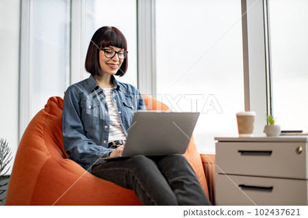 Pretty female having video conference on laptop in office Pretty female having video conference on laptop in office 102437621