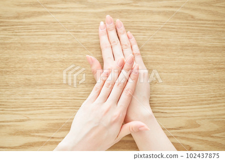 A woman's hand checking the condition of her nails 102437875
