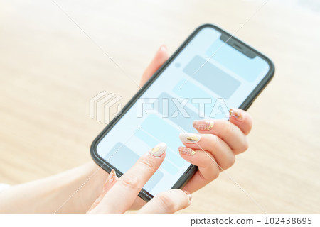 Hand of a woman who operates a smartphone 102438695