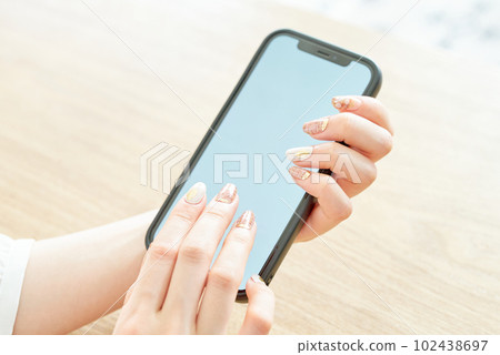 Hand of a woman who operates a smartphone 102438697