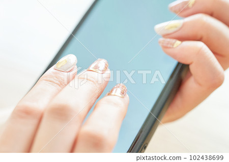 Hand of a woman who operates a smartphone 102438699