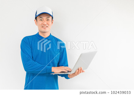 A man of a moving company / delivery person with a personal computer (moving / delivery / light cargo driver / home delivery / delivery person / courier service) 102439033