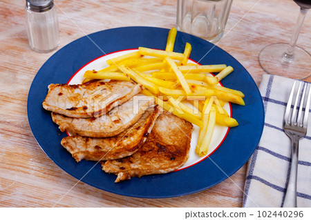 Baked pork meat with garnish of fried potato Baked pork meat with garnish of fried potato 102440296