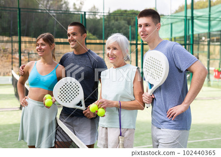 Portrait of four happy padel players on tennis court outdoor Portrait of four happy padel players on tennis court outdoor 102440365