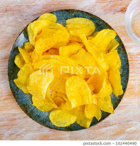 Plate of crispy deep-fried chips of thinly sliced potatoes Plate of crispy deep-fried chips of thinly sliced potatoes 102440490