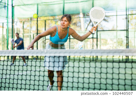 Padel game - woman with partners plays on tennis court Padel game - woman with partners plays on tennis court 102440507