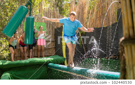 Man walking through water obstacle course in amusement park Man walking through water obstacle course in amusement park 102440530