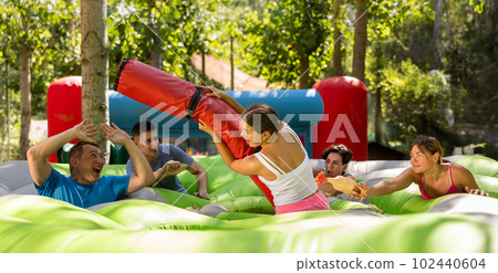Group of men and women playing funny game in summer amusement park 102440604