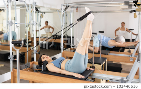 Young asian girl performing pilates exercises on reformer 102440616