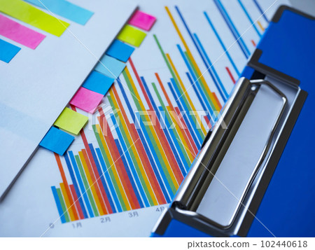 Binders and graphs on the table, documents with sticky notes 102440618