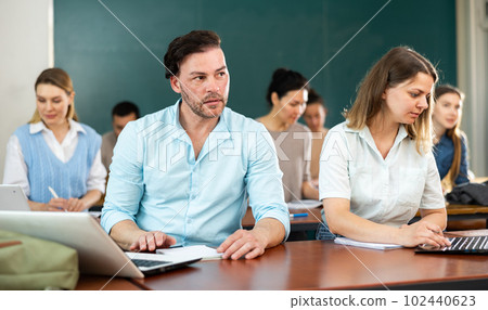 Focused students write down the lecture synopsis during the class Focused students write down the lecture synopsis during the class 102440623