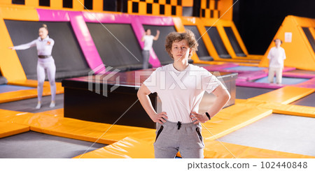 Young guy posing on trampoline workout in trampoline center 102440848