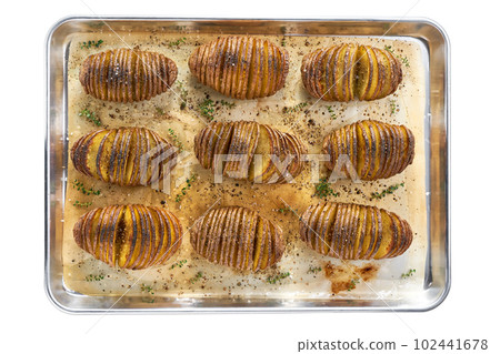 baked Hasselback potato on a baking tray isolated on a white background, top view. baked Hasselback potato on a baking tray isolated on a white background, top view. 102441678