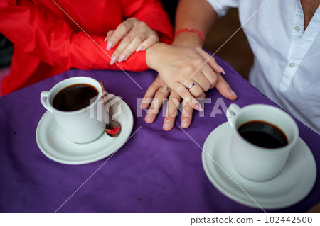 Man and woman, newlyweds holding hands with blurred background. 102442500
