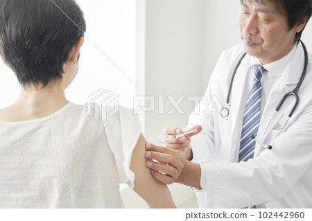 Middle-aged woman getting an injection in her arm 102442960
