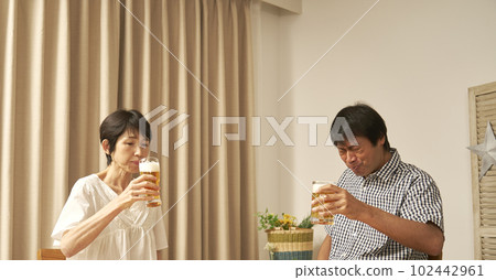 A mature couple who drinks at home 102442961