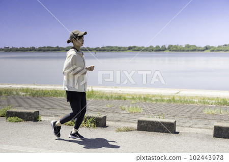 一個女人在河床上慢跑 一個女人在河床上慢跑 102443978
