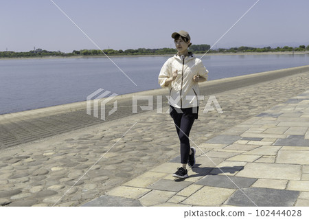 A woman jogging a riverbed 102444028