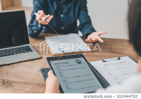 HR managers are interviewing job applicants who fill out their resume on the job application form in order to consider accepting a job as a company 102444702
