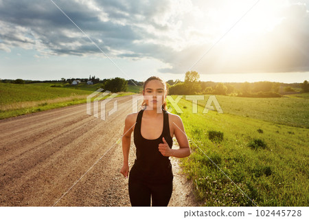 Im getting stronger every day. a fit young woman power walking outside on a beautiful day. 102445728